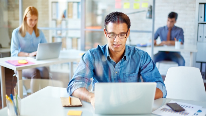 Business people sitting at workplaces and working in office
