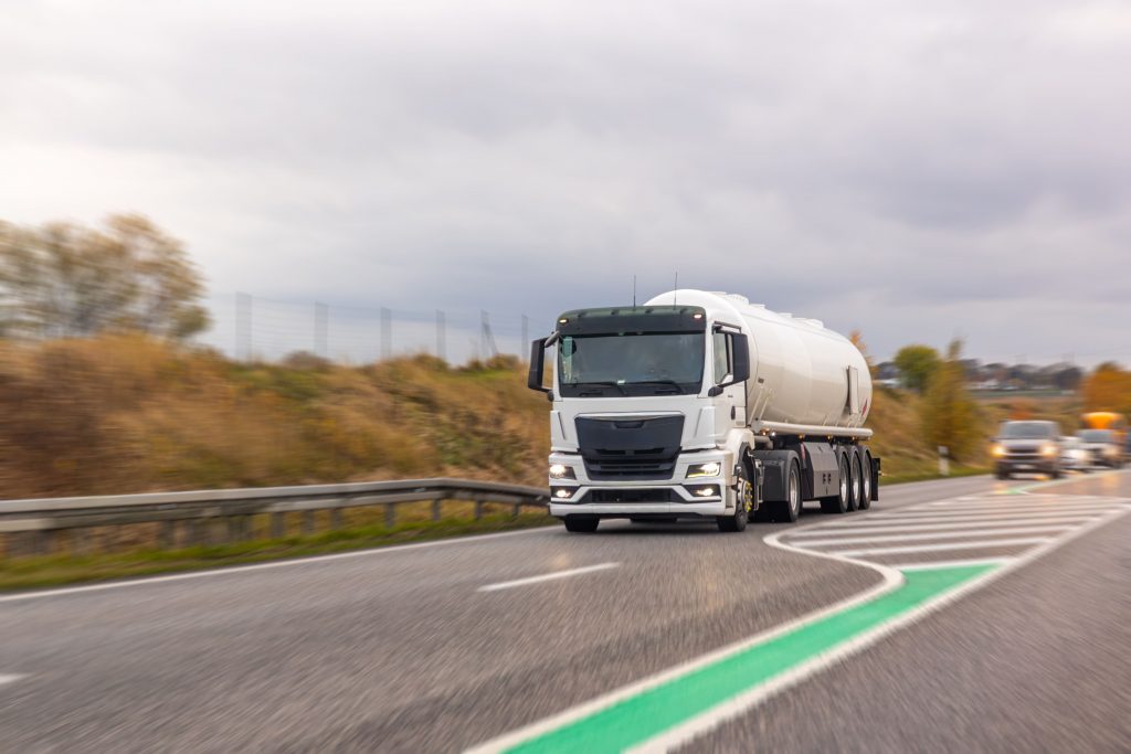 white-tanker-truck-races-along-highway-cloudy-daylight-fuel-logistics