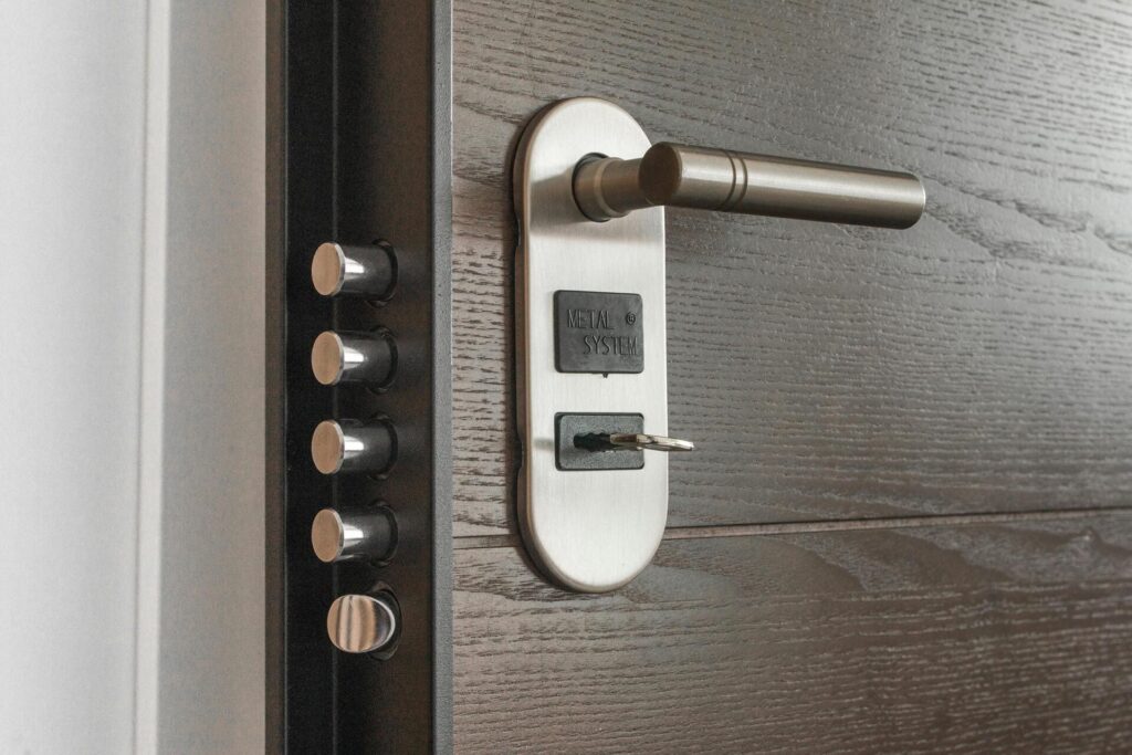 Cerradura de seguridad con manilla metálica y llave en puerta.