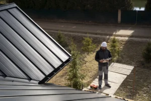 Trabajador inspeccionando una cubierta metálica industrial desde un andamio durante la instalación o revisión del aislamiento térmico