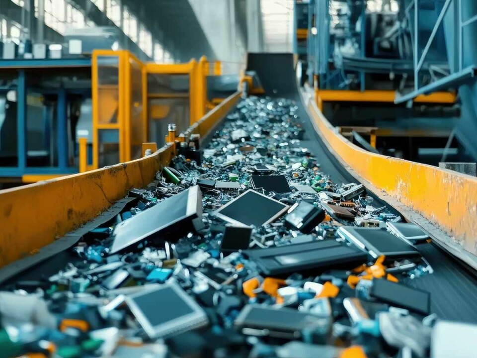 Cinta transportadora industrial con residuos electrónicos y materiales reciclables en una planta de gestión y reciclaje de residuos