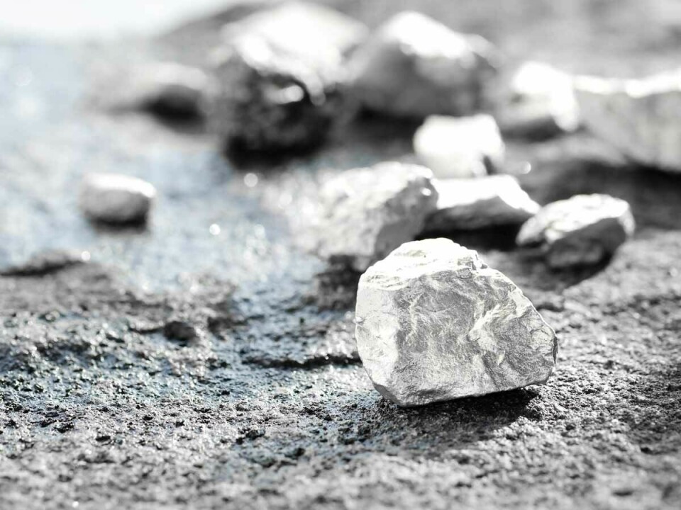 Fragmentos de mineral de platino sobre una superficie oscura, representando materias primas utilizadas en la industria metalúrgica.