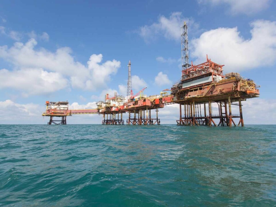Plataforma petrolífera en alta mar dedicada a la extracción de petróleo, rodeada por el océano bajo un cielo despejado.