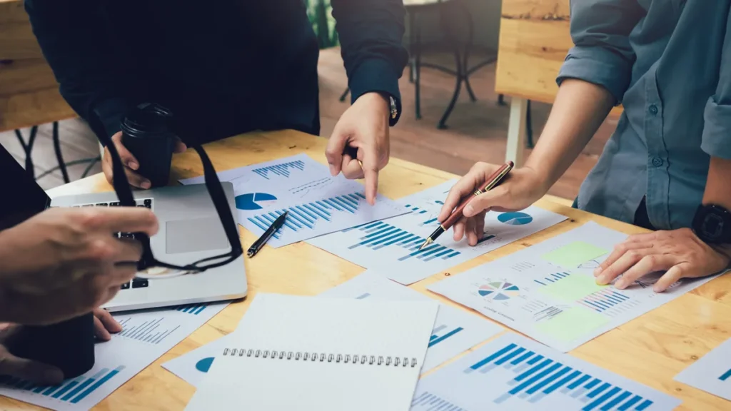 Equipo analizando documentos y gráficos para explicar cómo hacer un análisis PESTEL.