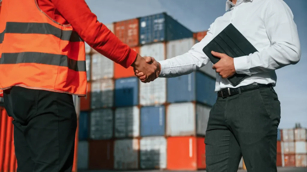 Profesionales cerrando un acuerdo en puerto para explicar la carta de crédito internacional.