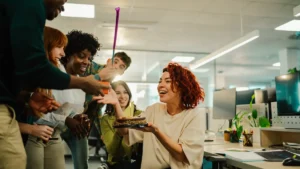 Equipo celebrando en oficina para ilustrar el clima laboral en la empresa.