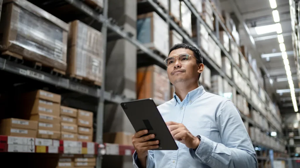 Responsable de almacén usando una tablet para revisar KPIs logísticos.