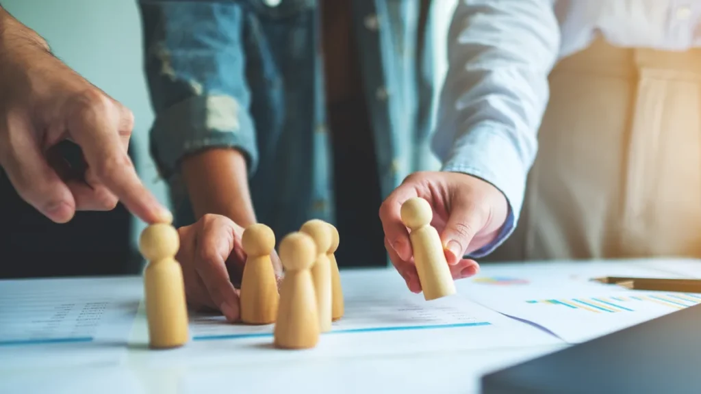 Figuras de madera sobre una mesa para representar la planificación de recursos humanos.
