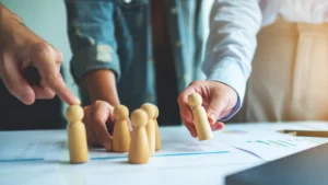 Figuras de madera sobre una mesa para representar la planificación de recursos humanos.