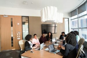 Reunión de mujeres profesionales en una sala de conferencias con ordenadores portátiles durante una sesión de trabajo empresarial.