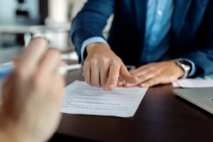 Abogado señalando el lugar de firma en un contrato durante una reunión con un cliente