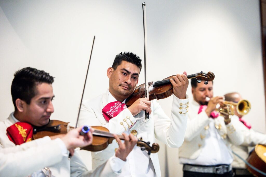 Mariachis en Bogotá tocando violín y trompeta durante una serenata tradicional.
