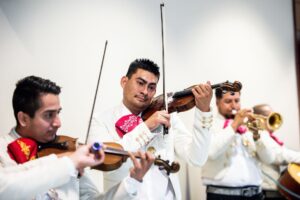 Mariachis en Bogotá tocando violín y trompeta durante una serenata tradicional.