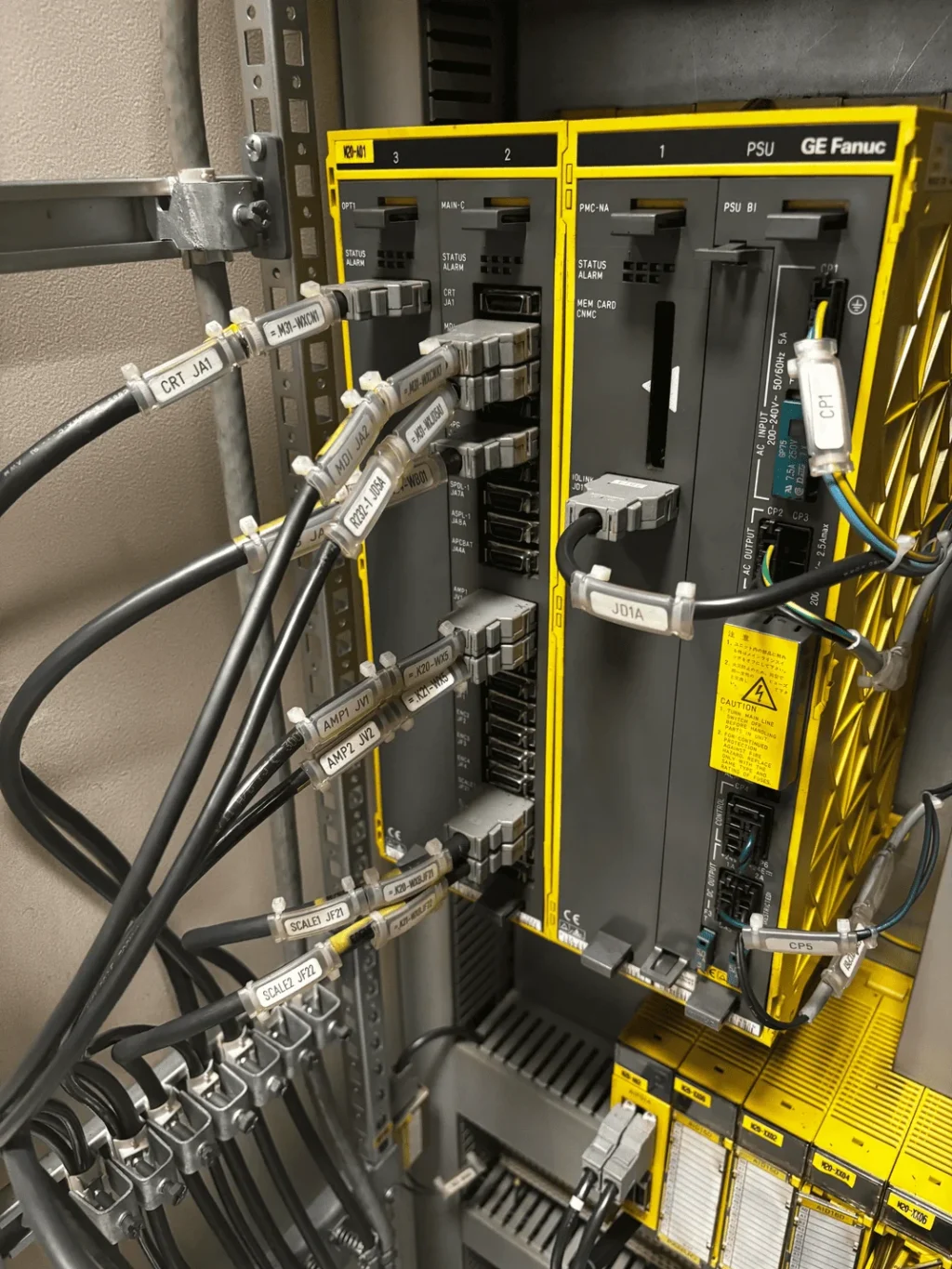 Armario de control industrial con sistema CNC FANUC, módulos electrónicos y cableado de conexiones.